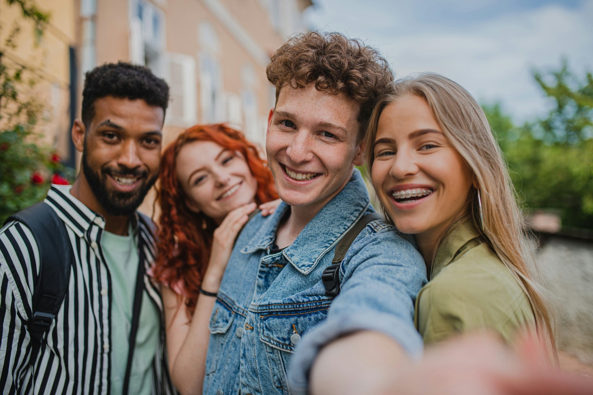 Four friends taking a selfie together on a city street